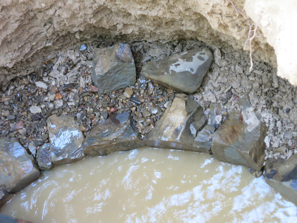 The wall comes up neatly. A layer of small round pebbles are placed behind the big frontal stones to prevent return of sand when water flows in.